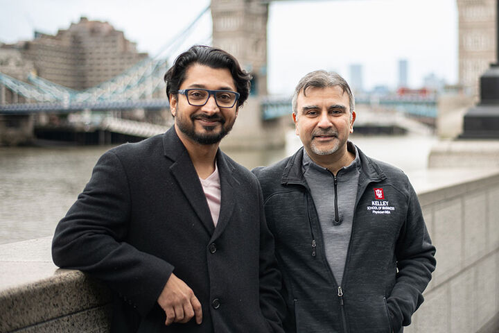 Two men wearing Physician MBA Program attire stand on a bridge in London.